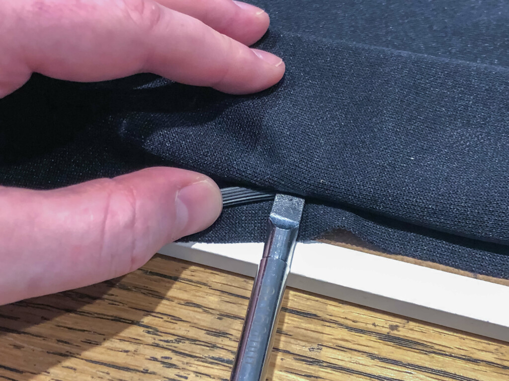 A screwdriver pressing spline in to the gap